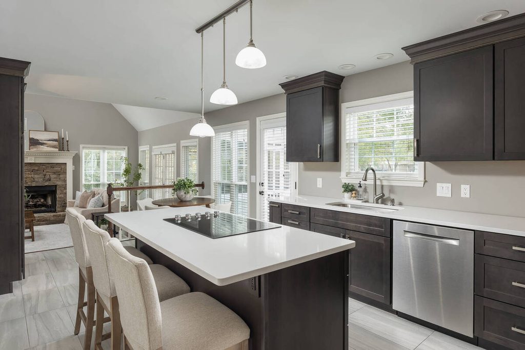 Modern kitchen with island and dark cabinets.
