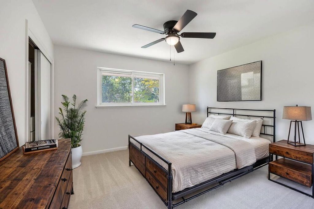 Staged bedroom with wood and metal bed.